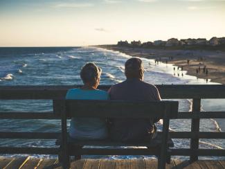 Old couple sitting on the beach