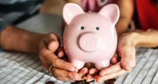 Family holding piggy bank together